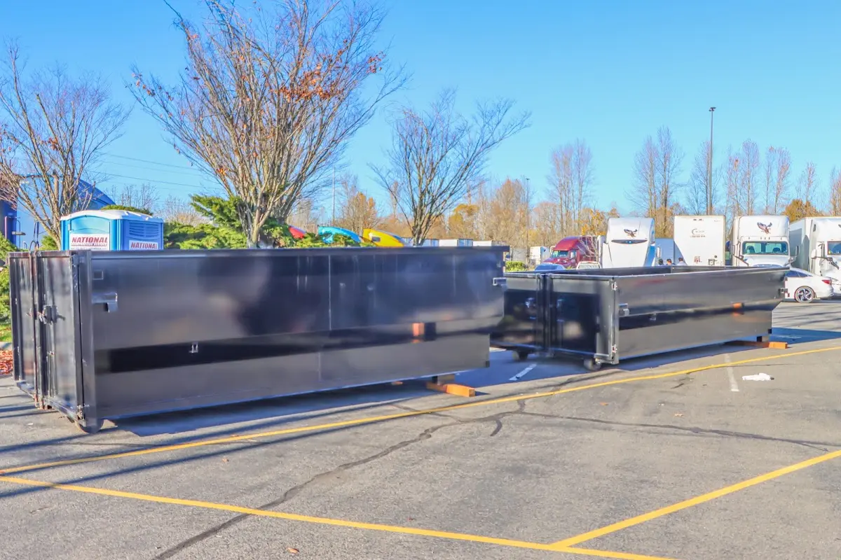 Professional dumpster rental service with roll-off container on residential driveway in East Huntingdon